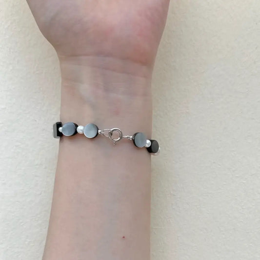 Freshwater pearl bracelet mixed with black shell worn on wrist showing spring clasp Orienlu