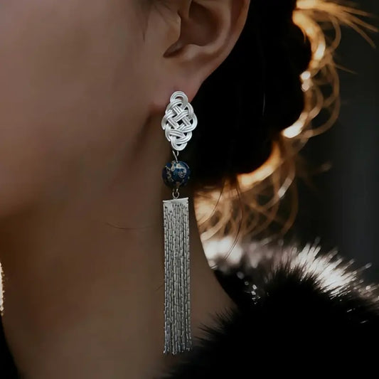 Chinese knot statement earrings worn on ear with silver tassel cascading