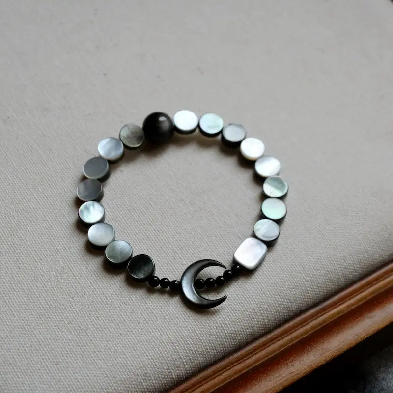 Close-up of crescent moon mother of pearl charm on moon shell bracelet