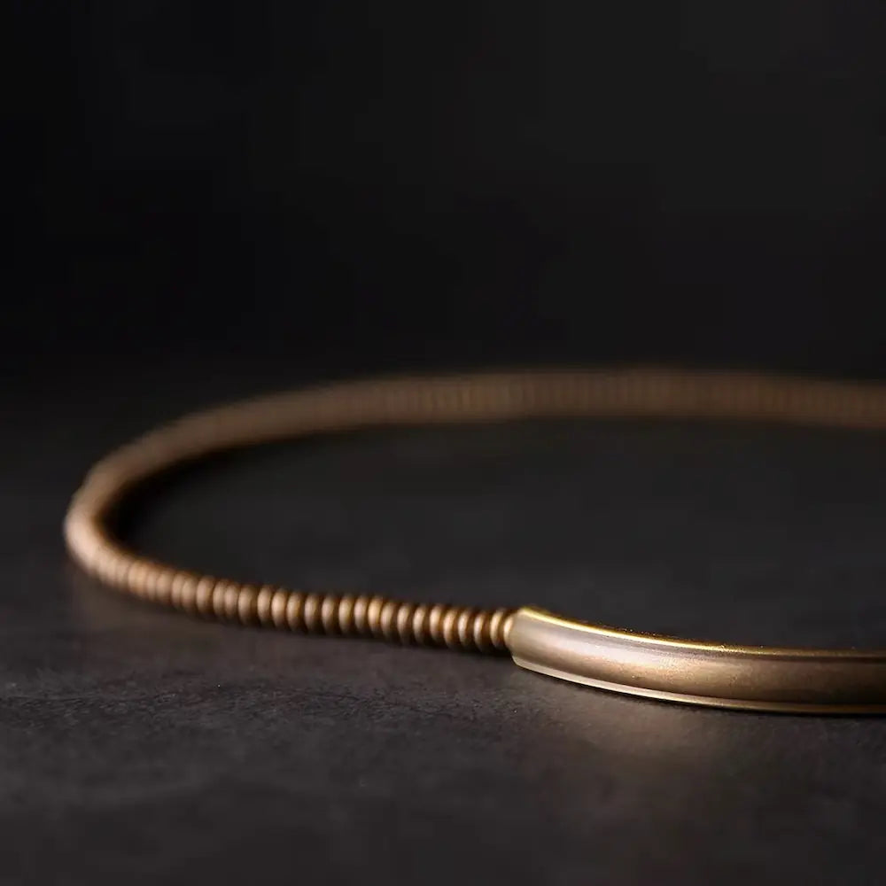 Close-up of vintage gold brass tube and abacus beads on black lava rock bracelet — Orienlu