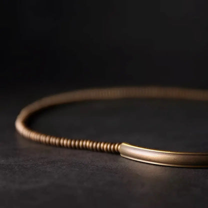 Close-up of vintage gold brass tube and abacus beads on black lava rock bracelet — Orienlu
