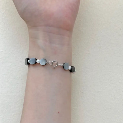 Freshwater pearl bracelet mixed with black shell worn on wrist showing spring clasp Orienlu