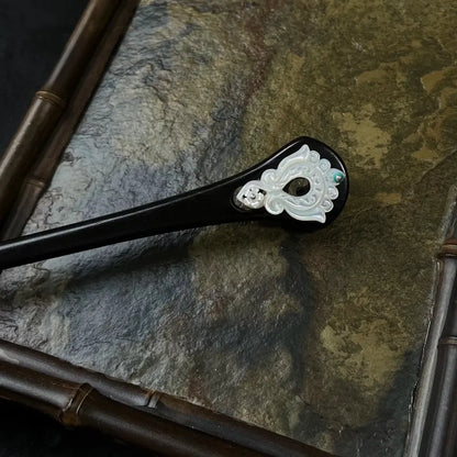Handcrafted black ebony wood hair stick featuring a beautifully carved mother of pearl inlay and a small green magnesite gemstone accent.