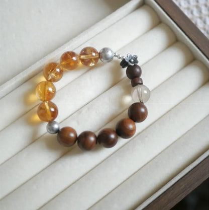 Close-up of yellow citrine beads, sandalwood, and smoky quartz on crystal wood bracelet — Orienlu