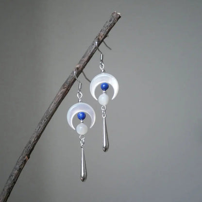 Dangle moon earrings hanging on a branch showing silver cone drop pendant Orienlu