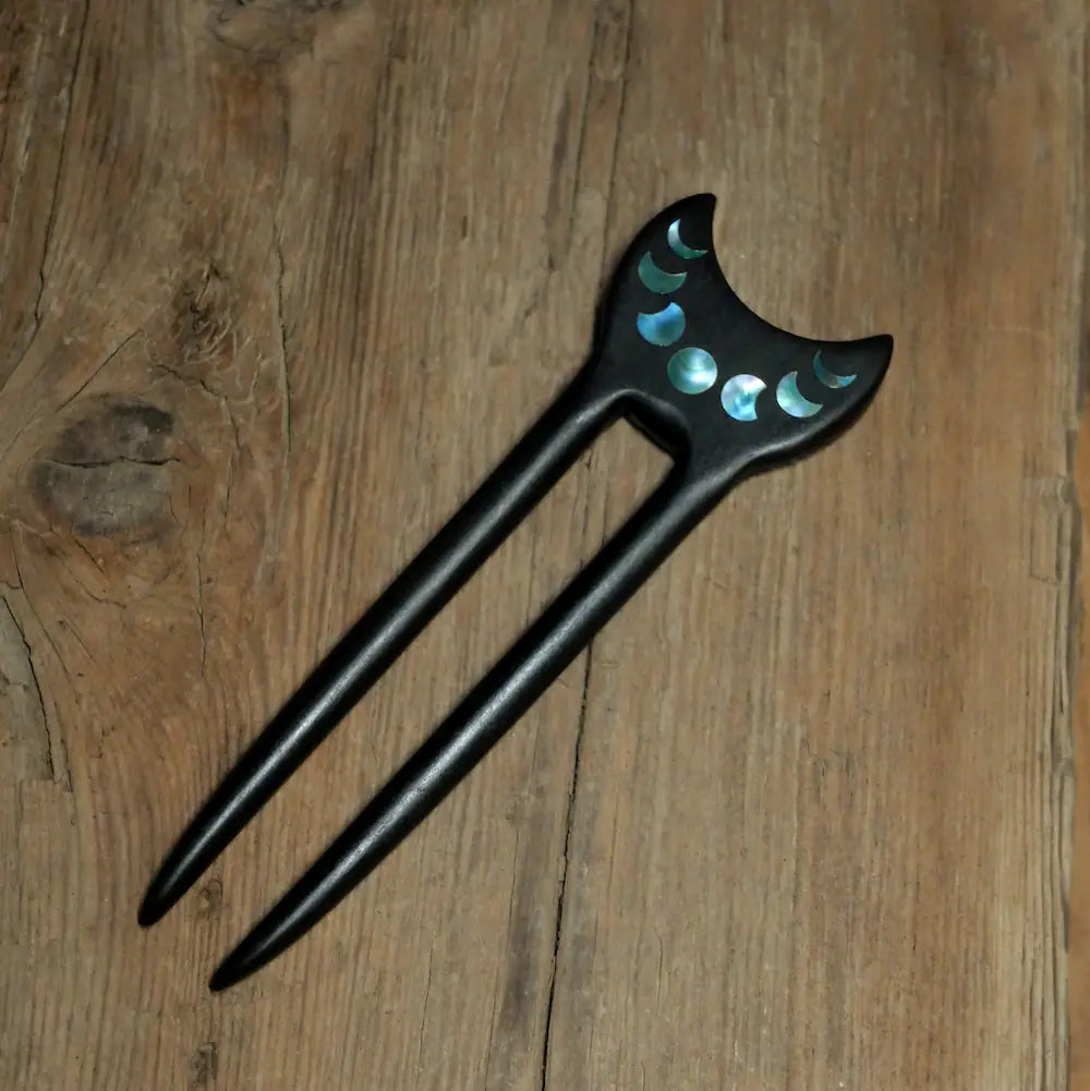 Handcrafted ebony crescent moon phase hair fork with abalone and mother of pearl inlay on rustic wood background Orienlu