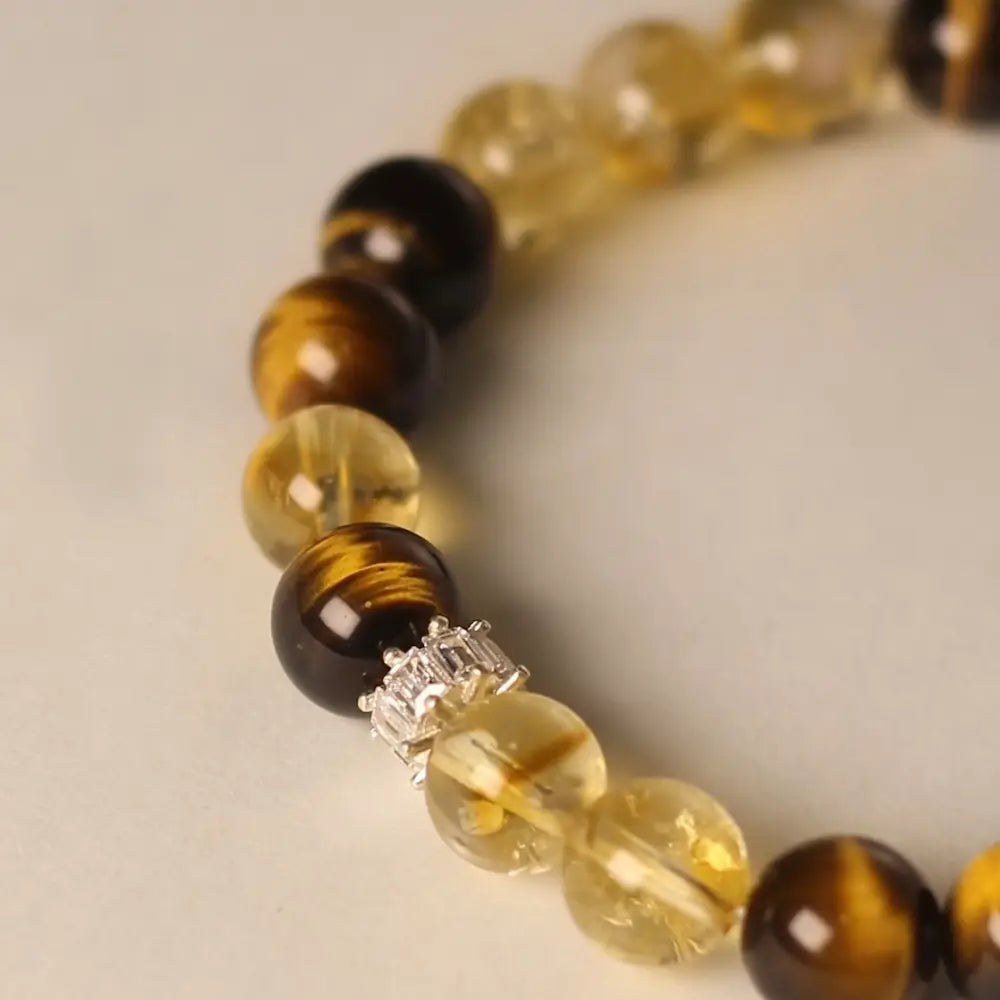 Close-up of alternating golden citrine, brown tiger's eye rounds, and sparkling zircon spacer Orienlu