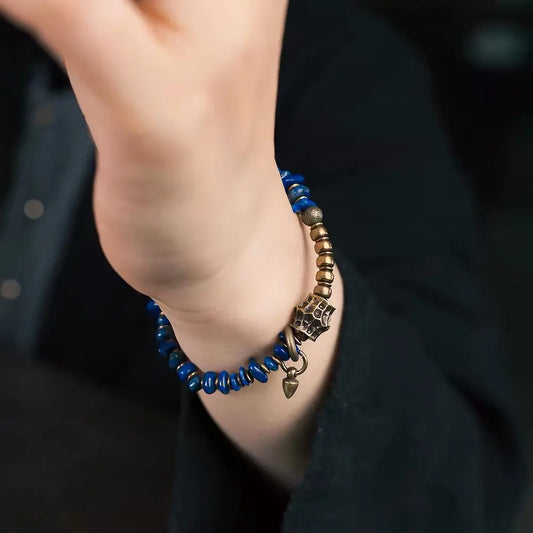 Lapis lazuli chip bracelet worn as boho layering piece with brass pendant on wrist — Orienlu