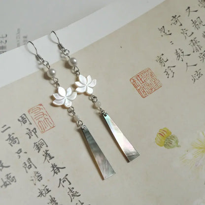Long lotus drop earrings with iridescent black mother of pearl pendant on Chinese calligraphy background Orienlu