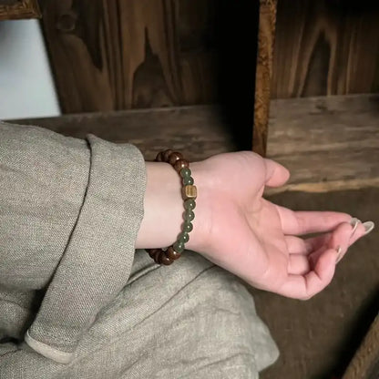 Sandalwood and jade bracelet worn on wrist in natural light 