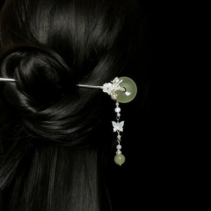 Back view of a woman styled with a sleek dark hair bun, secured by the Orienlu green agate donut hair pin, illustrating the natural drape and elegant movement of the pearl butterfly fringe.