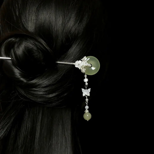 Back view of a woman styled with a sleek dark hair bun, secured by the Orienlu green agate donut hair pin, illustrating the natural drape and elegant movement of the pearl butterfly fringe.