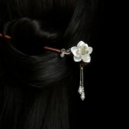 Orienlu official on-model product image of a 20cm natural bamboo hair stick inserted in a classic bun, featuring a mother of pearl blossom and a swaying freshwater pearl tassel.