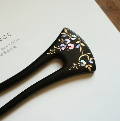 An angled top-view display of the Orienlu raden shell inlay hair fork on a clean white paper background, highlighting the brilliant luster of the heart-shaped mother of pearl petals and gold details.
