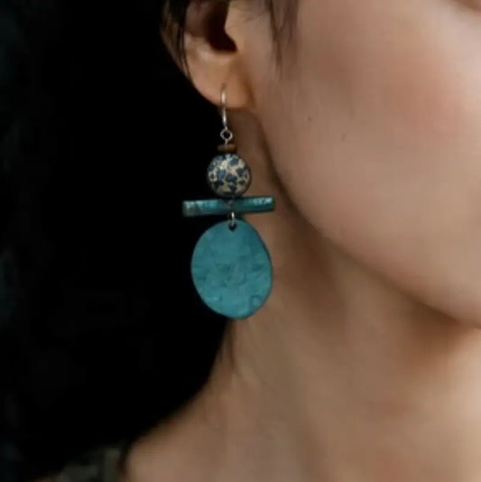  Bronze and lacquerware drop earrings worn on ear in natural lighting