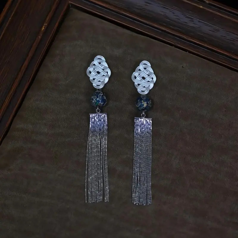 Close-up of chinese knot motif and blue-green lacquerware bead on tassel earrings