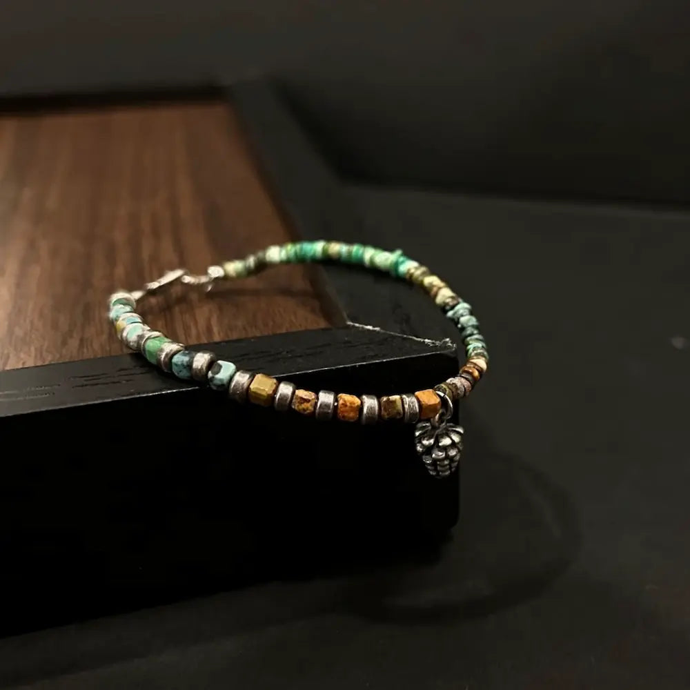 Close-up of jade green and tan quartzite abacus beads and metal pinecone pendant Orienlu