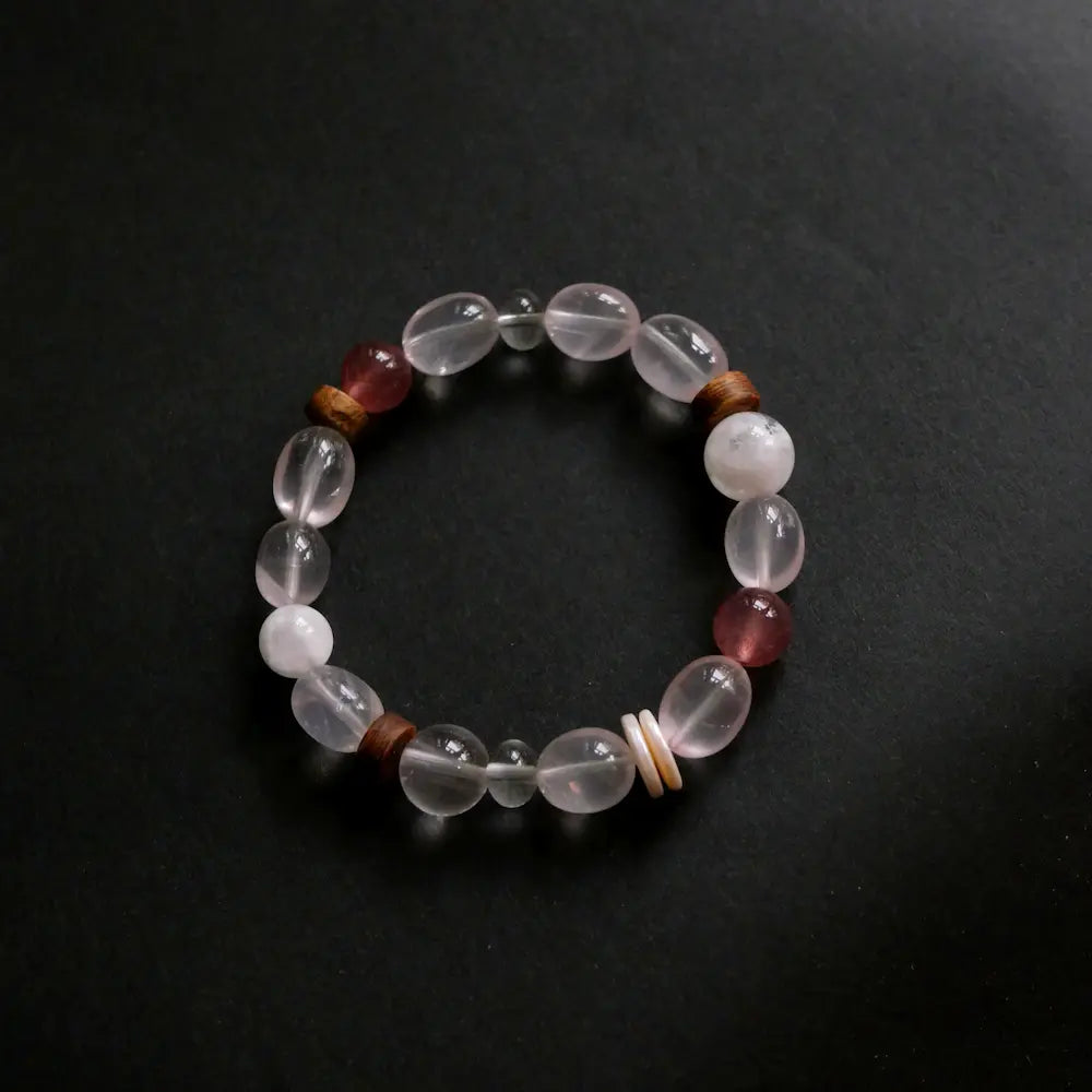 Handcrafted rose quartz bracelet with strawberry quartz and snowflake obsidian on dark background Orienlu