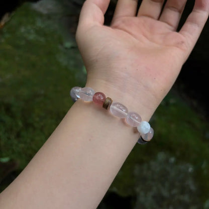 Rose quartz multi-stone bracelet worn on wrist showing soft pink and white tones against green background Orienlu