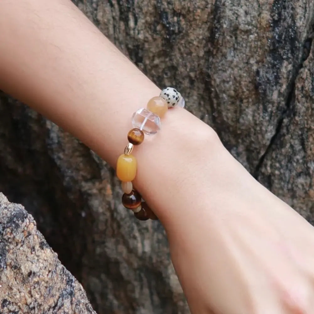 Tiger eye multi-stone beaded bracelet worn on wrist against natural rock background Orienlu